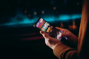 A close-up shot of golden coins falling around a spinning roulette wheel, representing immersive casino action at OKTKK.